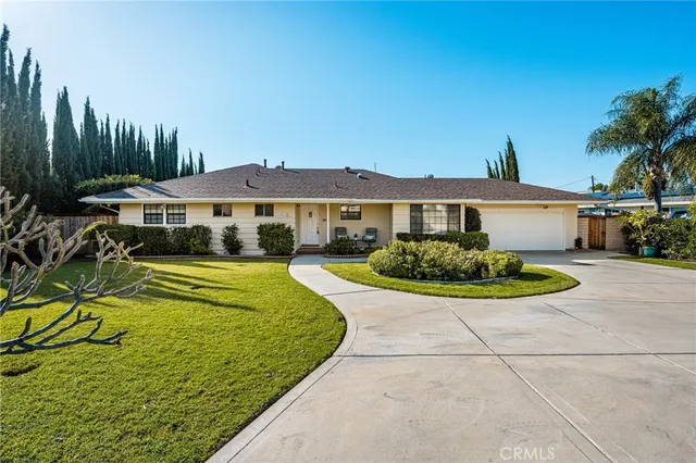 a view of a white house with a swimming pool and a yard