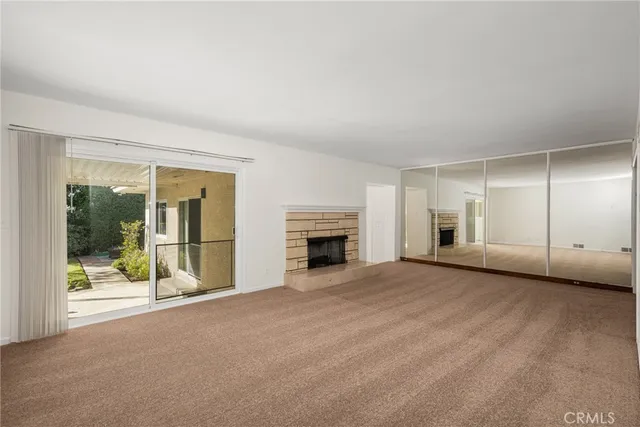 a view of an empty room with window and fire place