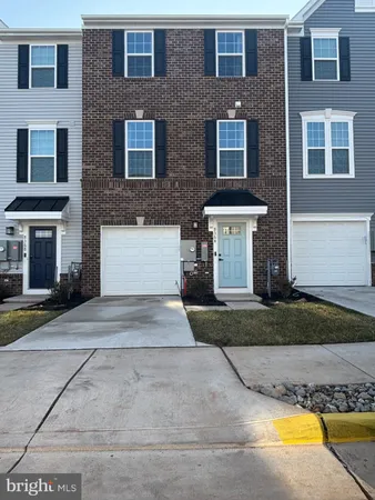 a front view of a brick house with a yard and a garage