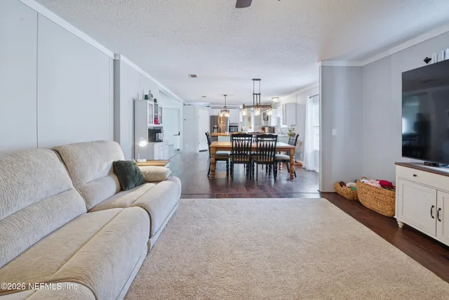 a living room with furniture and a dining table with kitchen view