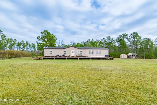 a front view of a house with a garden and deck