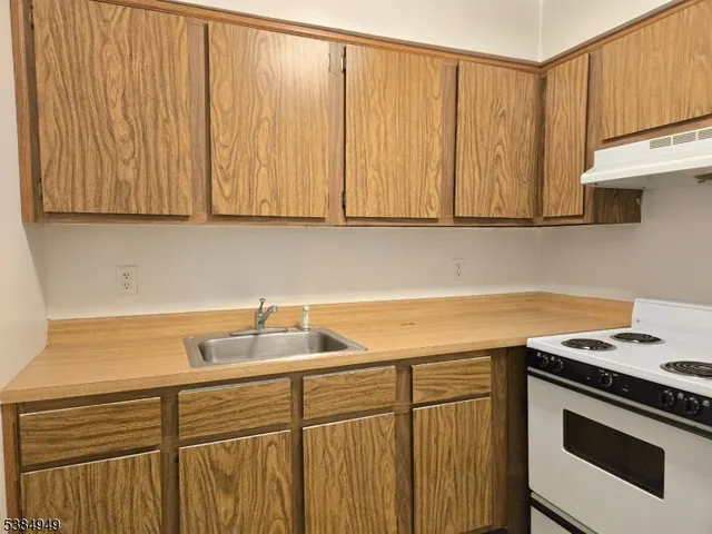 a kitchen with stainless steel appliances granite countertop a sink a stove and a microwave