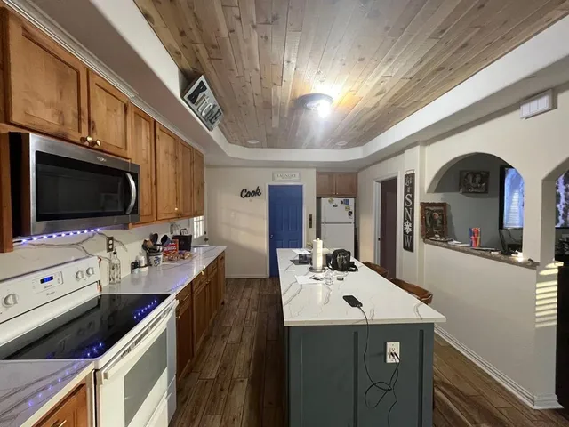 a kitchen with stainless steel appliances kitchen island granite countertop a sink and cabinets