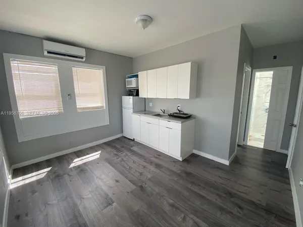 a view of a kitchen with wooden floor and electronic appliances