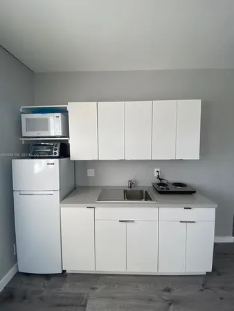 a kitchen with granite countertop white cabinets and white appliances