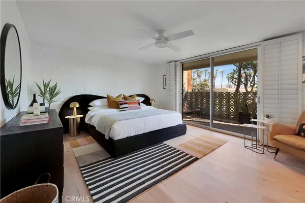 a bedroom with a bed a couch and a large window