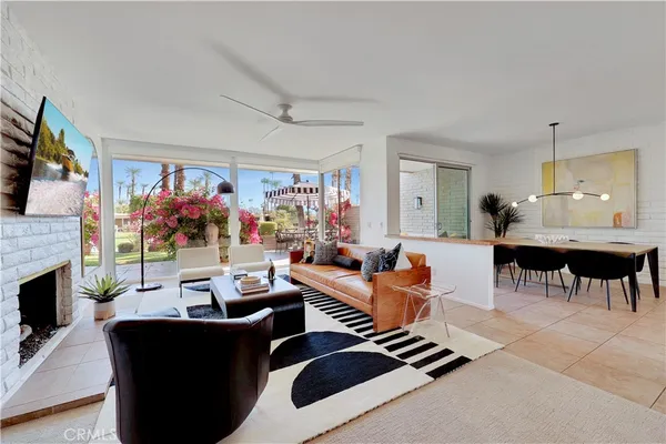 a living room with furniture a flat screen tv and a fireplace