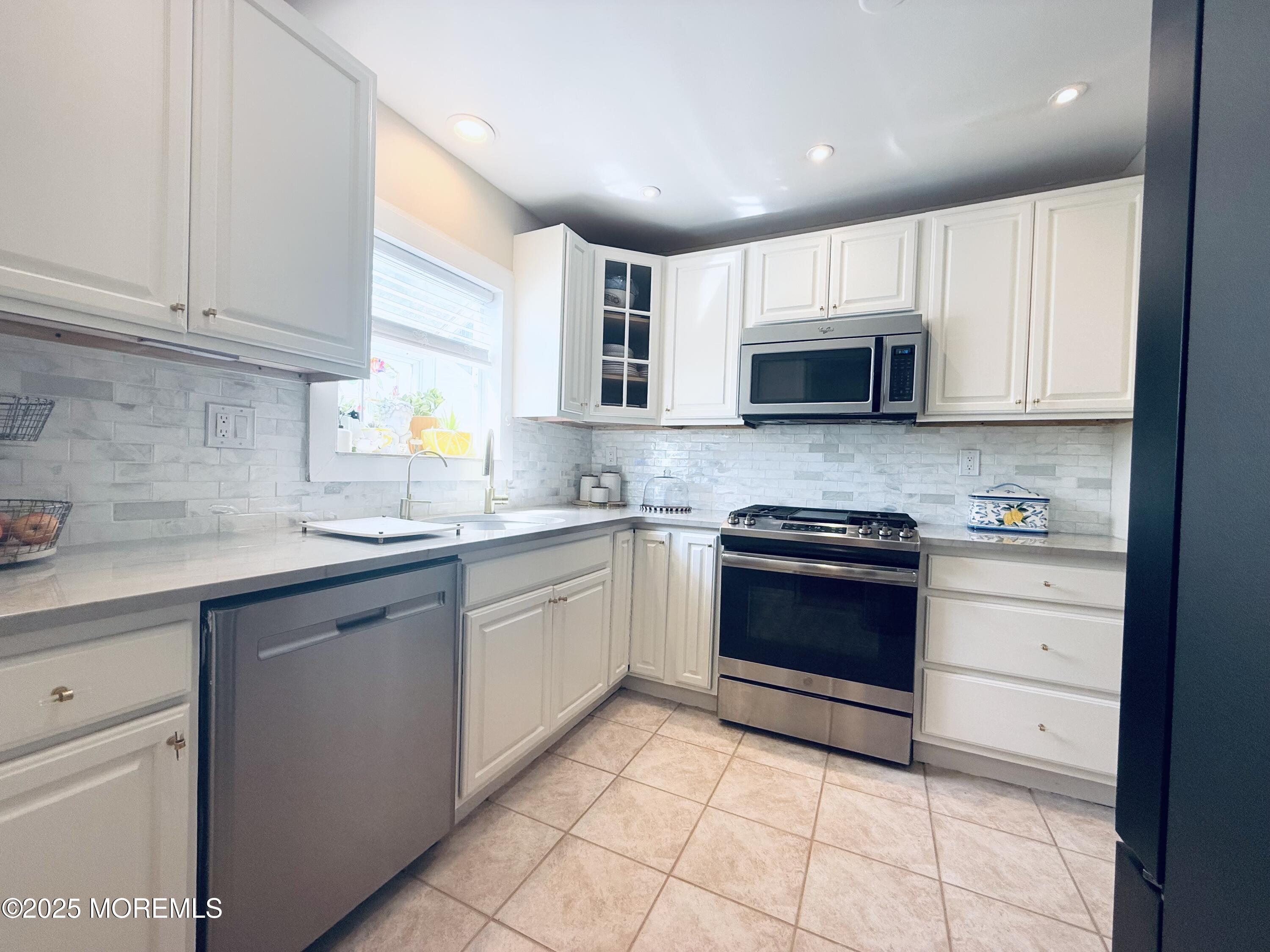 20 Long Road Freehold, NJ 07728 - Photo 6 of 20 a kitchen with stainless steel appliances granite countertop a stove sink and cabinets
