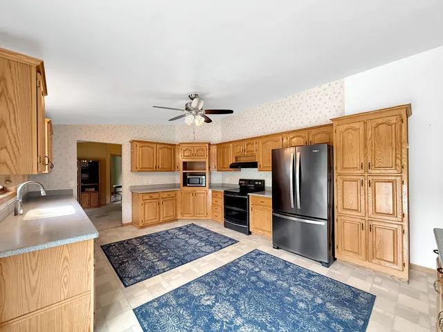 a kitchen with stainless steel appliances granite countertop a refrigerator stove top oven and sink