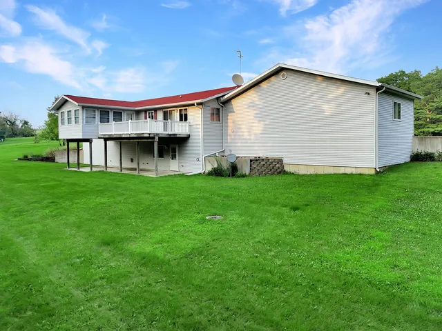 a view of a house with a yard and sitting area