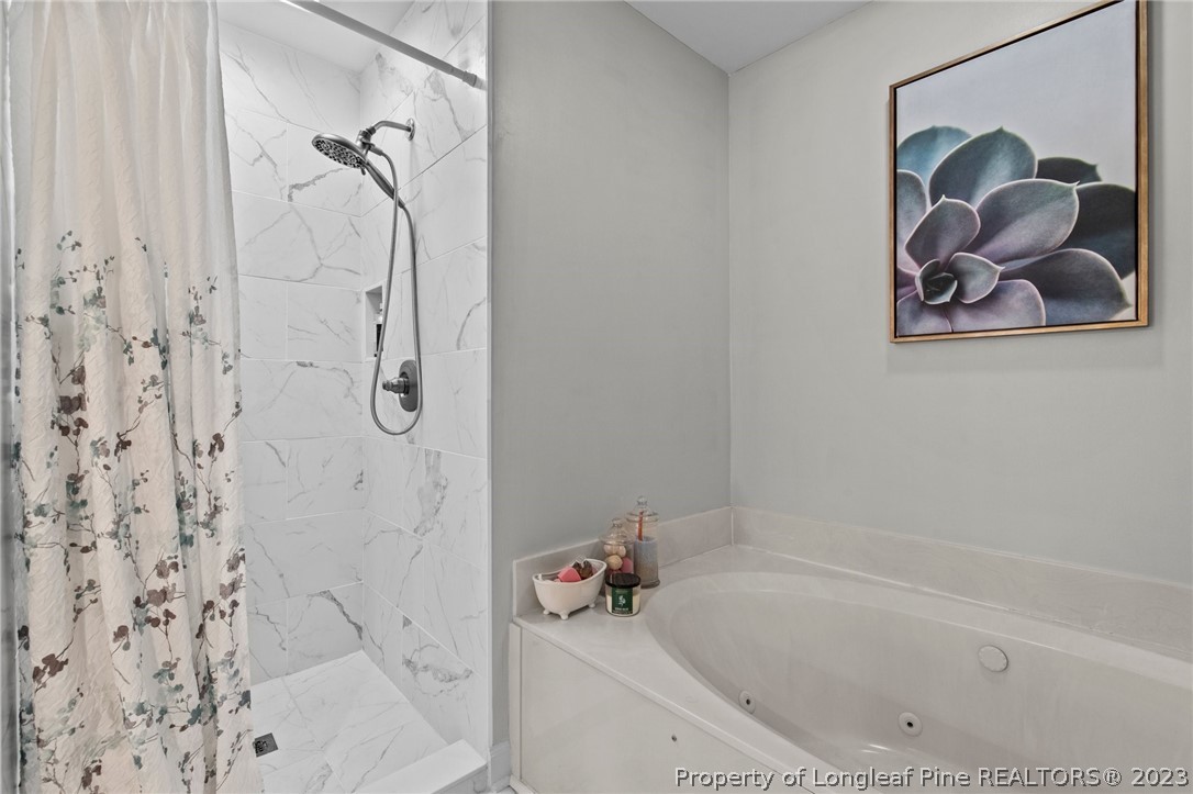 269 Knoll Road, Unit 409 Southern Pines, NC 28387 - Photo 19 of 40 a bathroom with a tub and a shower
