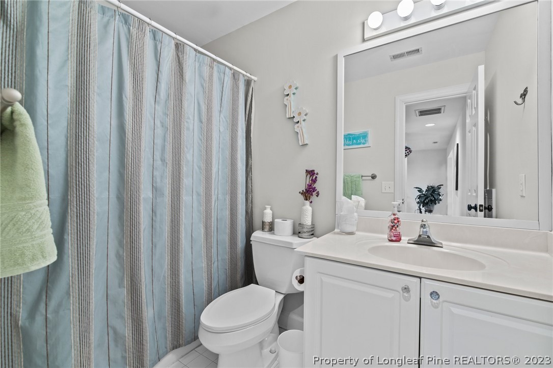 269 Knoll Road, Unit 409 Southern Pines, NC 28387 - Photo 27 of 40 a bathroom with a sink a toilet and shower curtain