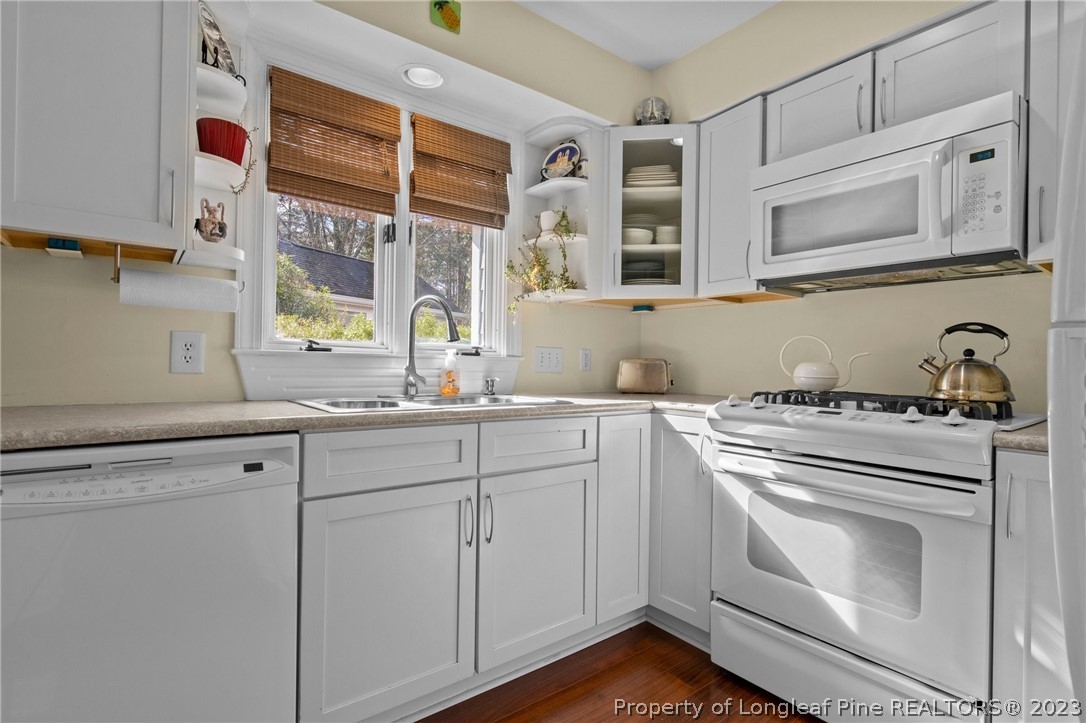 269 Knoll Road, Unit 409 Southern Pines, NC 28387 - Photo 8 of 40 a kitchen with granite countertop white cabinets and white appliances