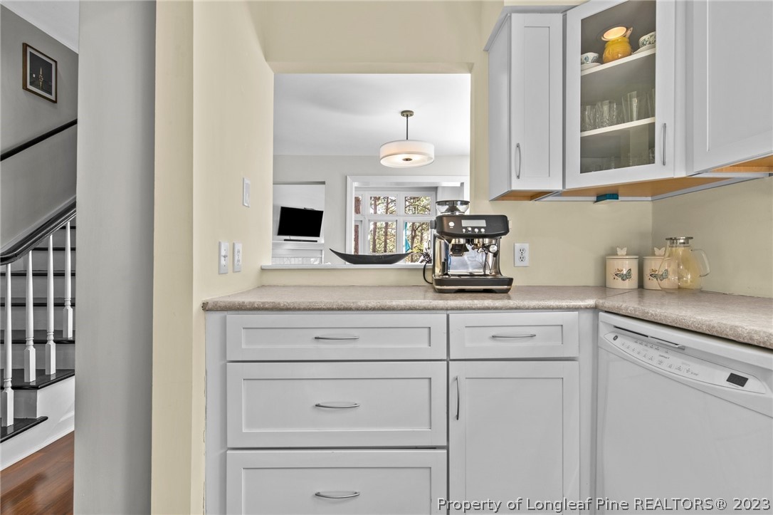 269 Knoll Road, Unit 409 Southern Pines, NC 28387 - Photo 9 of 40 a kitchen with white cabinets and sink