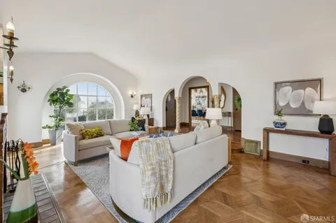 a view of a livingroom with furniture a chandelier and wooden floor