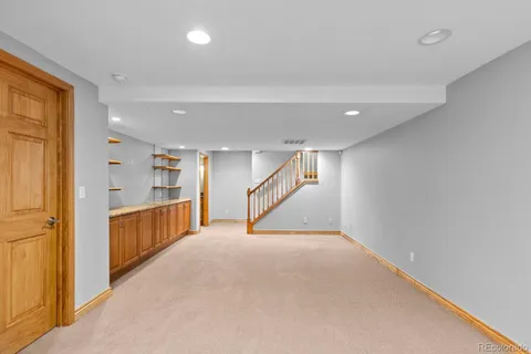 a view of an empty room with furniture and a window