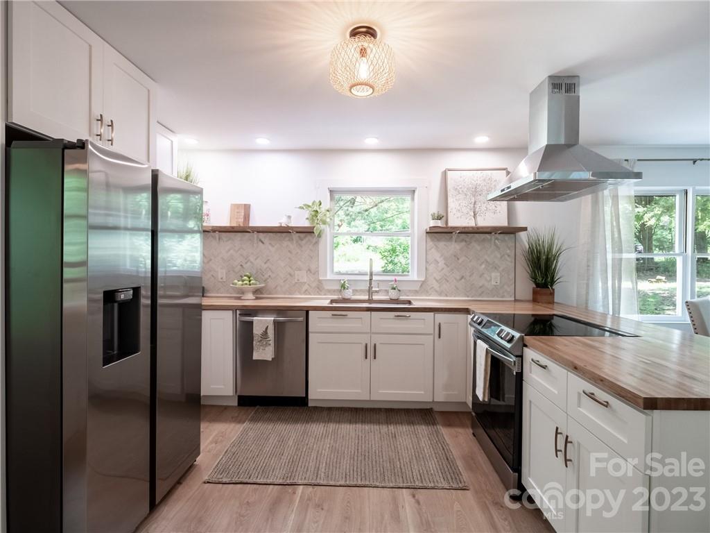 39 Cedar Mountain Road Asheville, NC 28803 - Photo 14 of 35 a kitchen with stainless steel appliances granite countertop a sink a stove a refrigerator and island