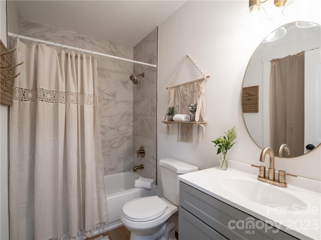 39 Cedar Mountain Road Asheville, NC 28803 - Photo 19 of 35 a bathroom with a sink a toilet a mirror and shower