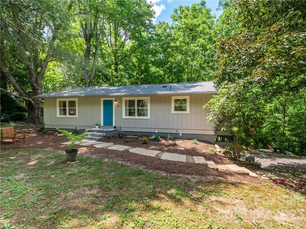 39 Cedar Mountain Road Asheville, NC 28803 - Photo 2 of 35 a backyard of a house with table and chairs