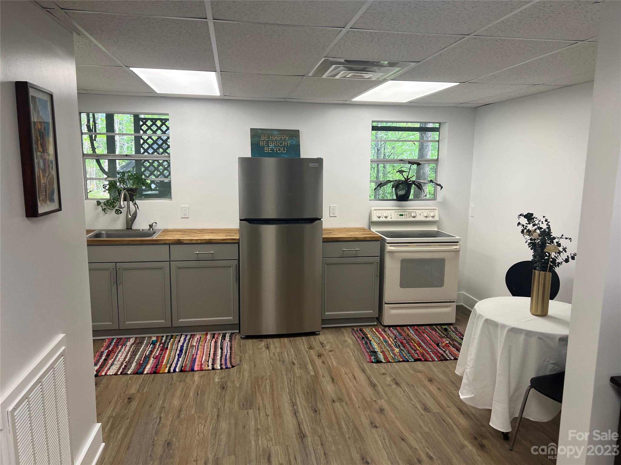 39 Cedar Mountain Road Asheville, NC 28803 - Photo 25 of 35 a kitchen with a refrigerator wooden floor a stove and a dining table
