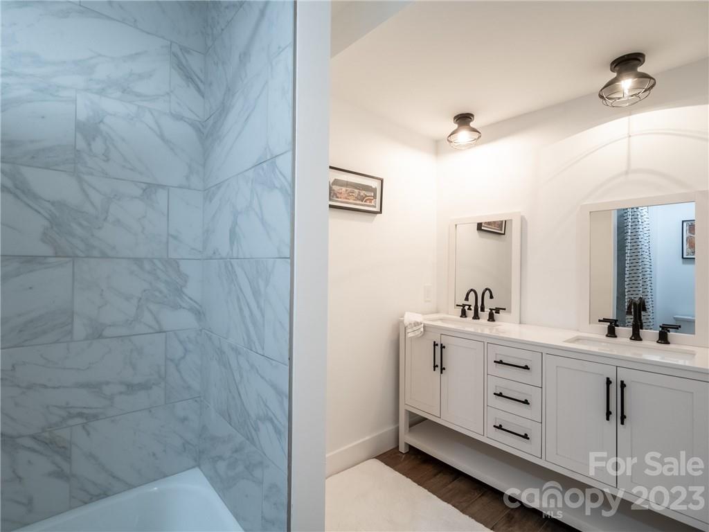 39 Cedar Mountain Road Asheville, NC 28803 - Photo 27 of 35 a bathroom with a double vanity sink a mirror and shower