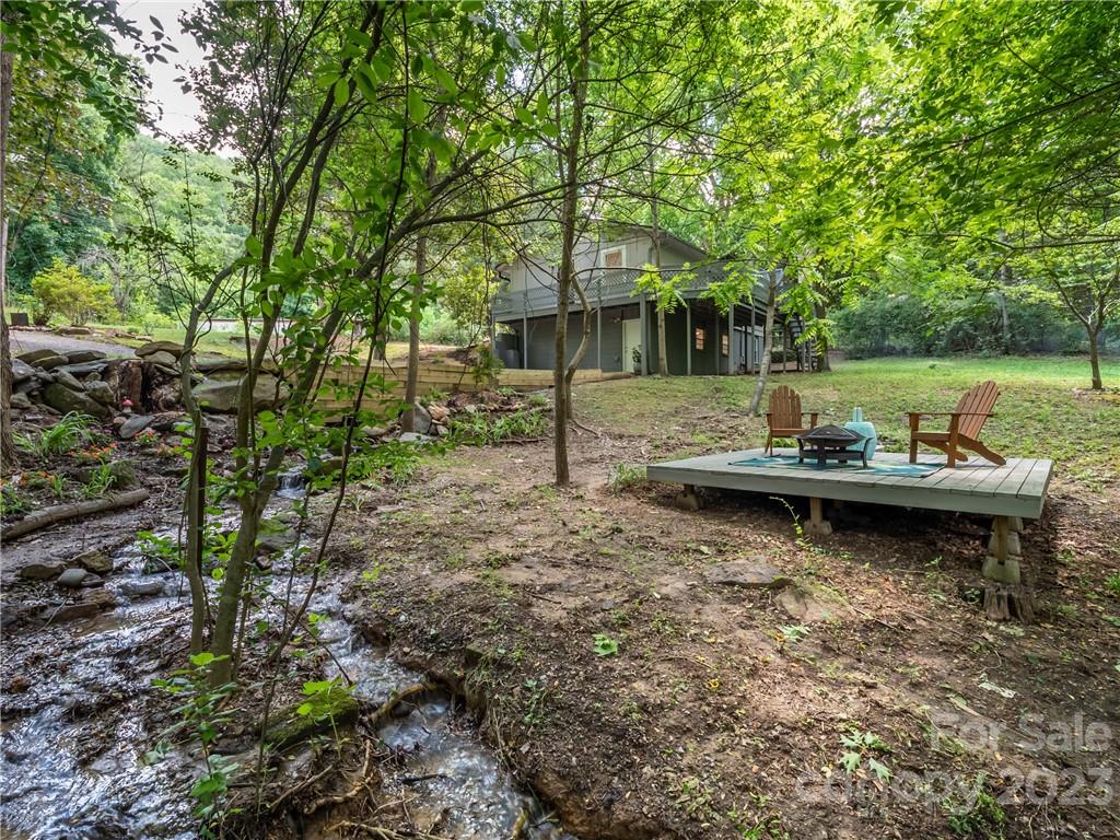 39 Cedar Mountain Road Asheville, NC 28803 - Photo 29 of 35 a view of a lake with lawn chairs and a large tree