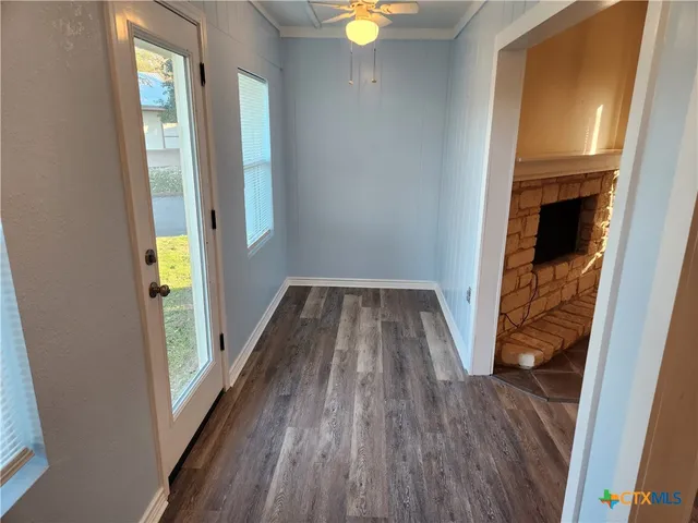 a view of a hallway with wooden floor and staircase
