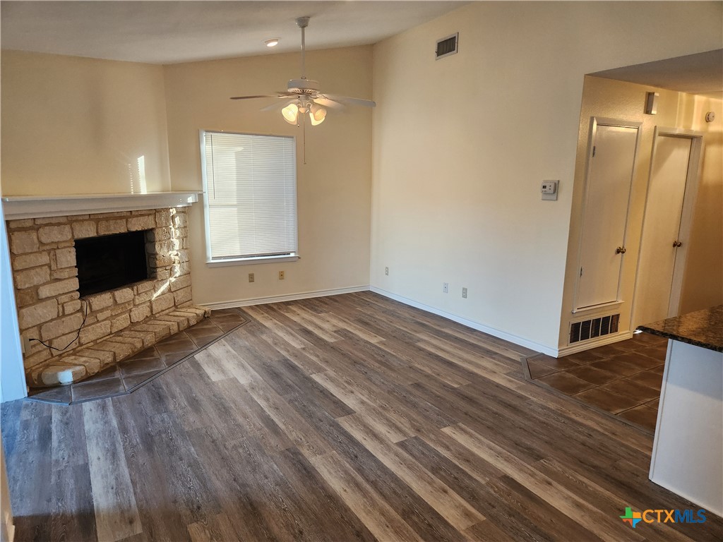 1015 Old Mill Road, Unit 4A Salado, TX 76571 - Photo 9 of 17 an empty room with wooden floor fireplace and windows