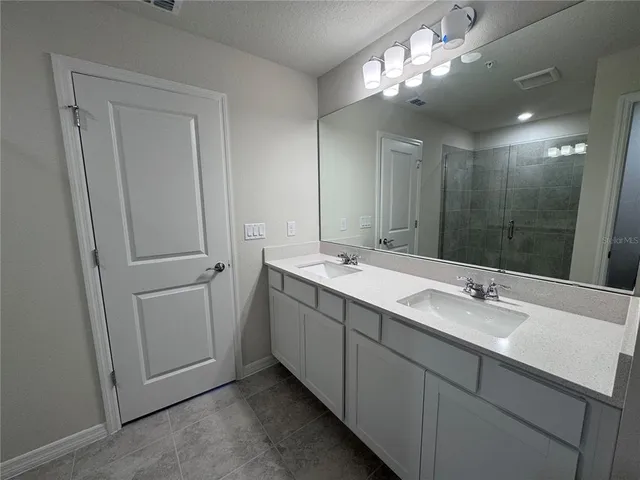 a bathroom with a double vanity sink and a mirror
