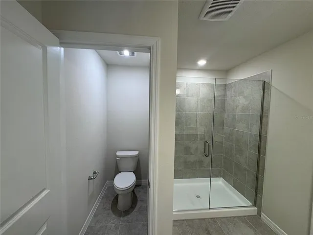 a bathroom with a shower a toilet and a sink