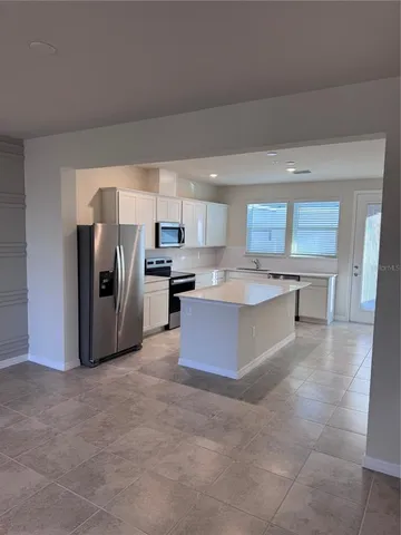 a large kitchen with a refrigerator and a sink