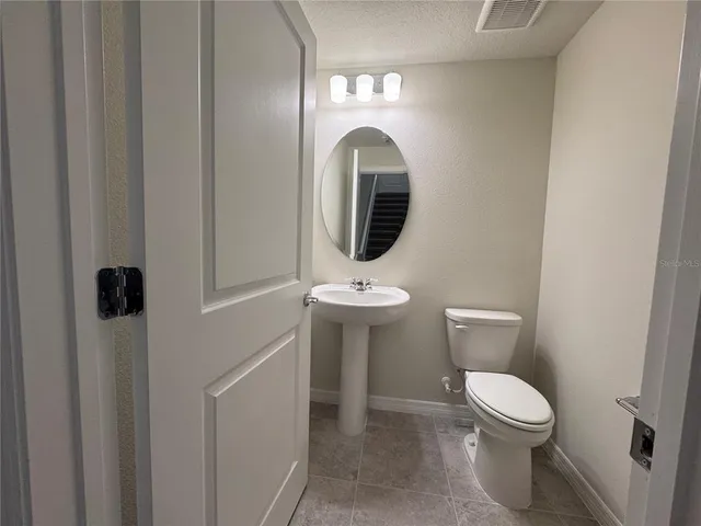 a bathroom with a toilet a sink and a mirror
