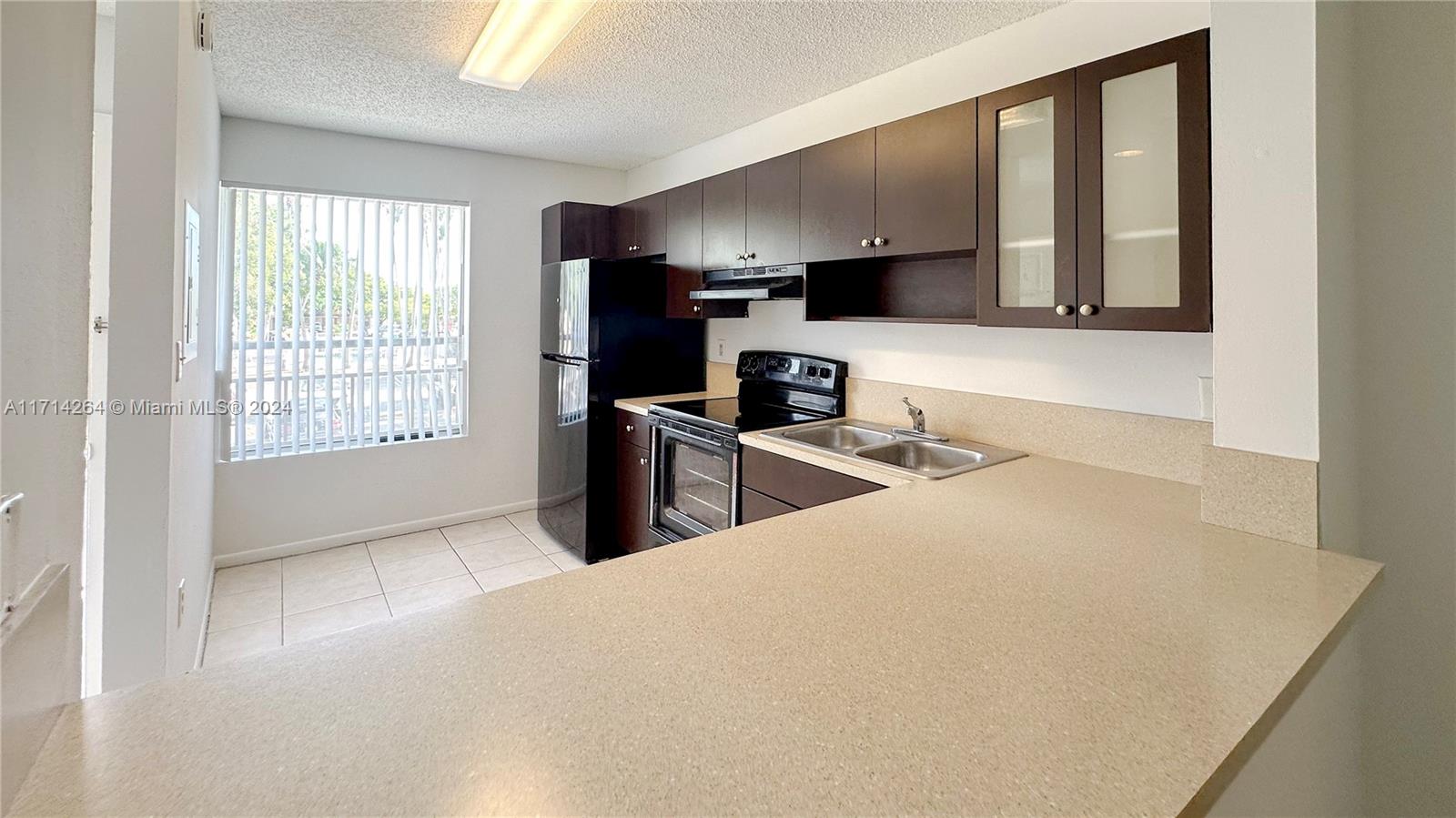 2218 Southwest 81st Avenue, Unit 2218 Miramar, FL 33025 - Photo 12 of 16 a kitchen with stainless steel appliances a microwave a sink and cabinets
