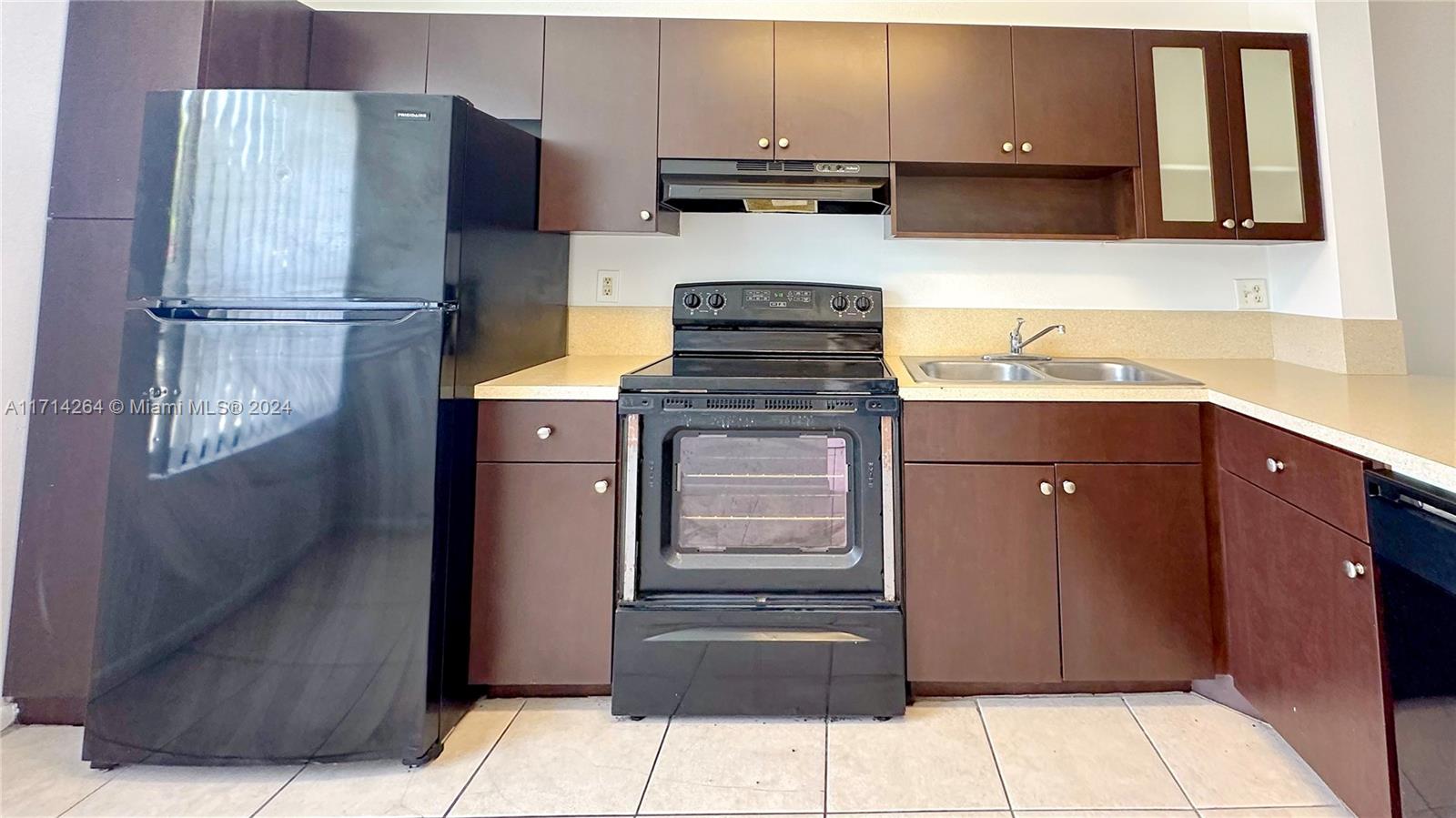 2218 Southwest 81st Avenue, Unit 2218 Miramar, FL 33025 - Photo 15 of 16 a kitchen with stainless steel appliances kitchen island granite countertop a refrigerator stove and sink