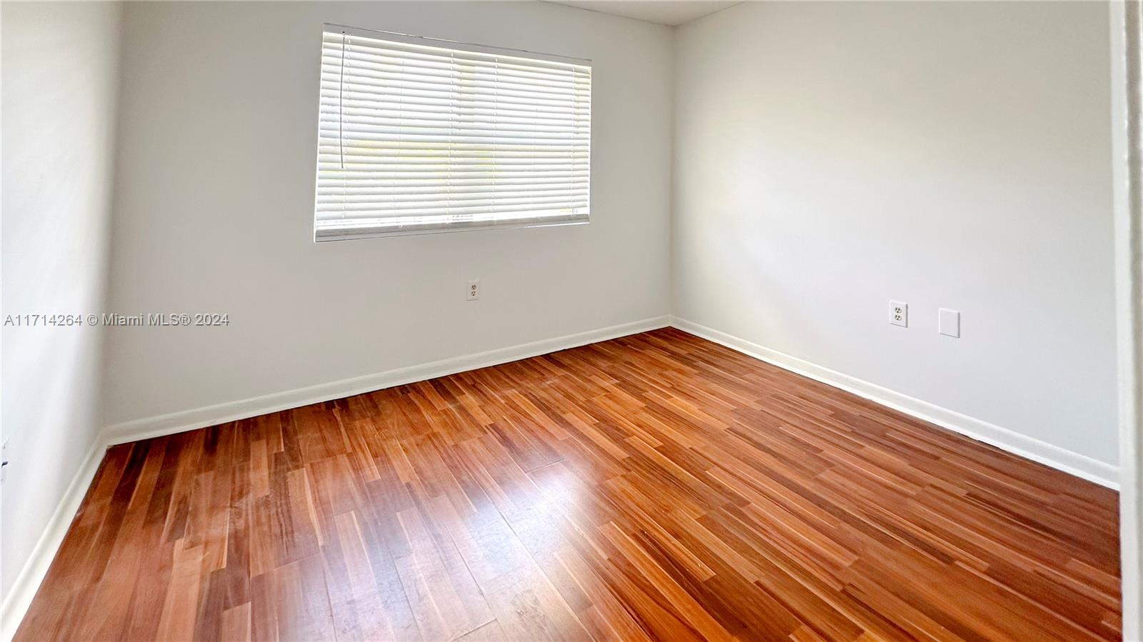 2218 Southwest 81st Avenue, Unit 2218 Miramar, FL 33025 - Photo 5 of 16 an empty room with wooden floor and windows