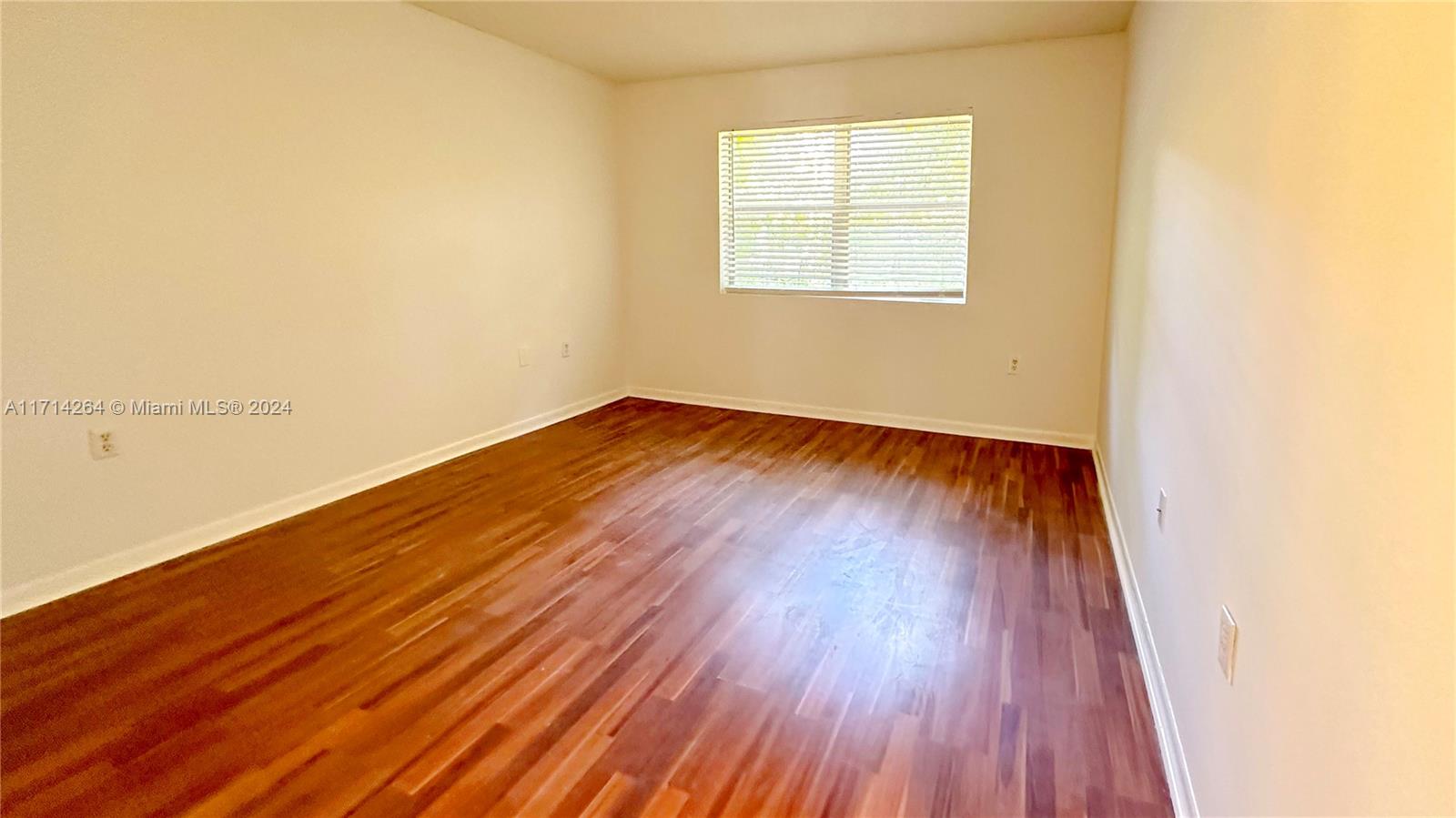 2218 Southwest 81st Avenue, Unit 2218 Miramar, FL 33025 - Photo 9 of 16 an empty room with wooden floor and windows