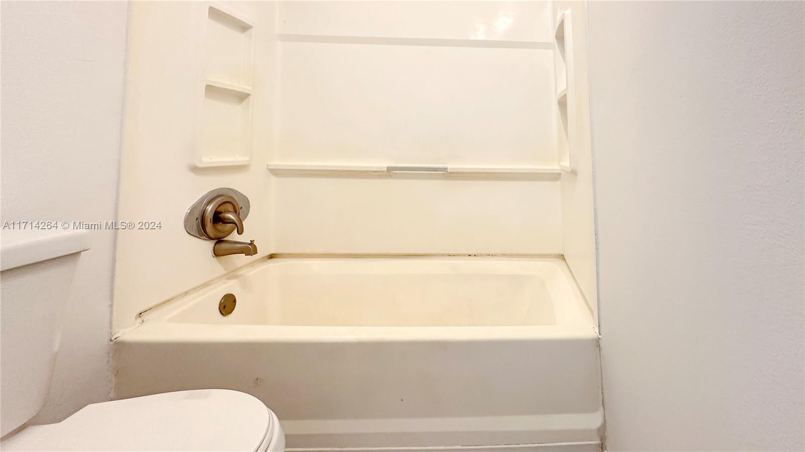 2218 Southwest 81st Avenue, Unit 2218 Miramar, FL 33025 - Photo 10 of 16 a bathroom with a tub and toilet