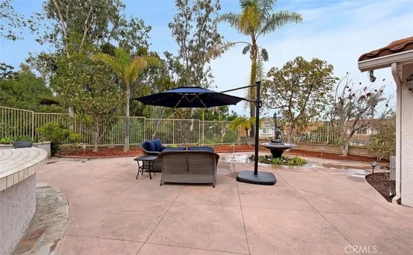 a view of a patio with couches and a table and chairs under an umbrella