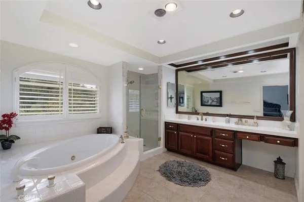 a spacious bathroom with a tub double sink mirror and