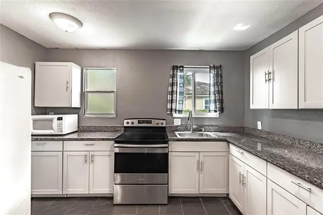 a kitchen with a stove sink and cabinets