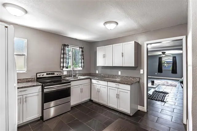 a kitchen with a stove sink and cabinets