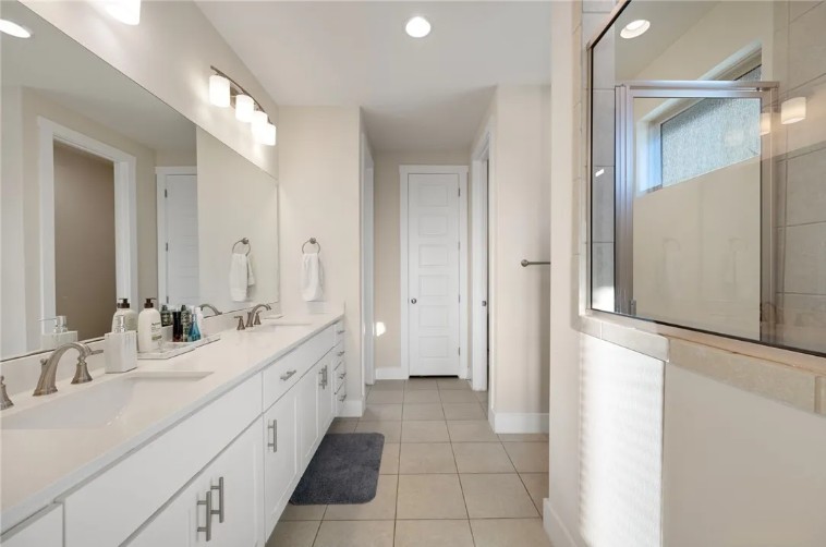 344 Pisa Lane Georgetown, TX 78628 - Photo 26 of 39 A long dual vanity and tiled flooring define this bright, functional primary bathroom space.