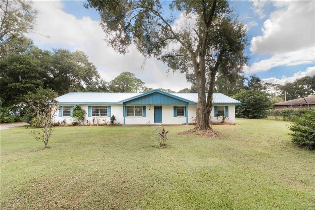 6923 Ranch Road Lakeland, FL 33809 - Photo 1 of 1 a front view of a house with a yard and trees