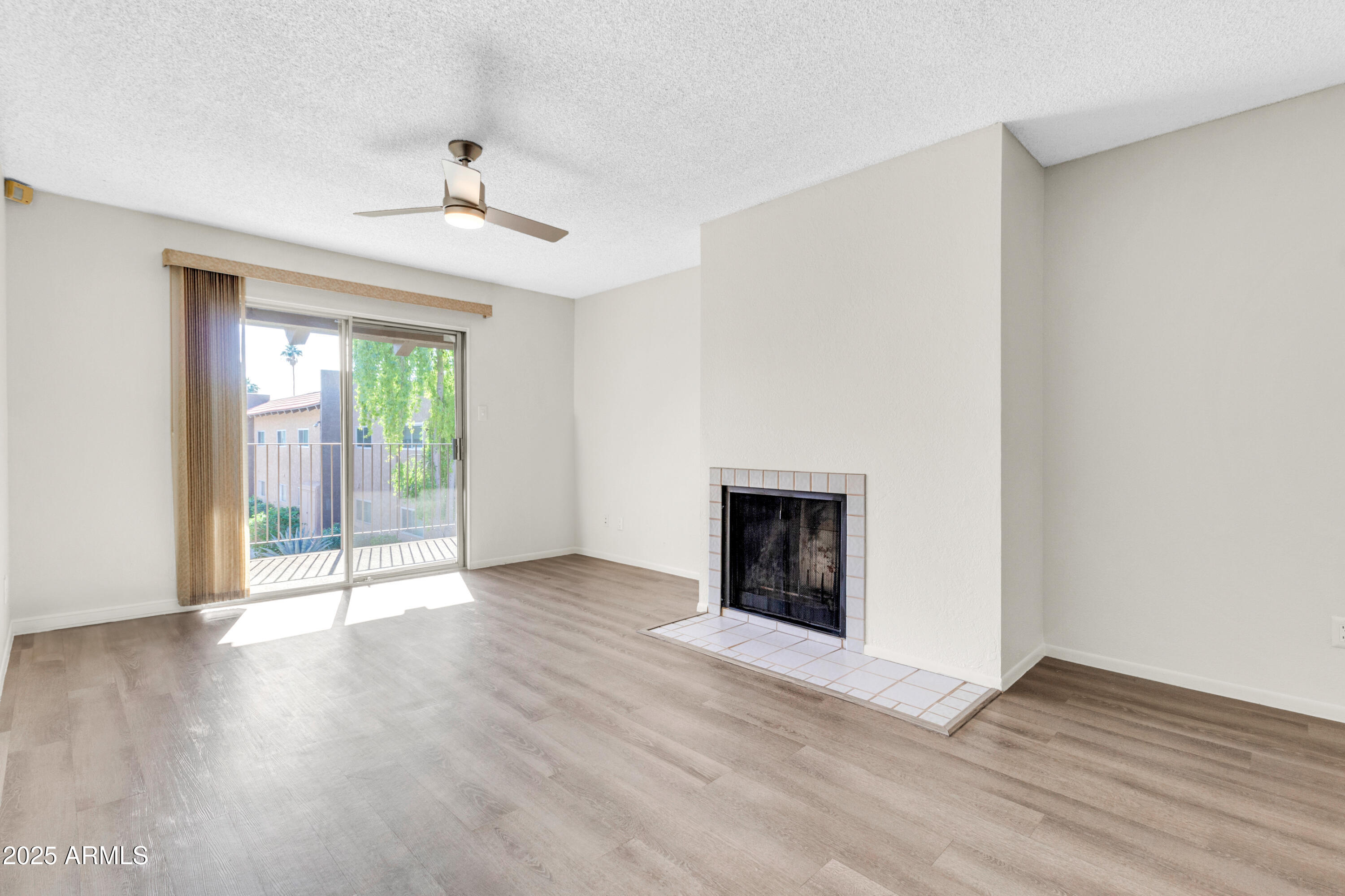 5525 East Thomas Road, Unit F9 Phoenix, AZ 85018 - Photo 10 of 48 an empty room with wooden floor fireplace and windows