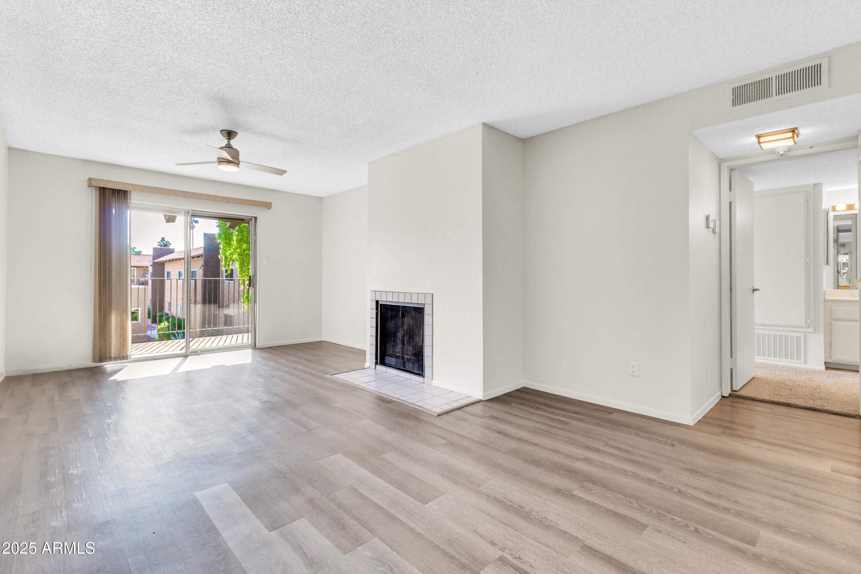 5525 East Thomas Road, Unit F9 Phoenix, AZ 85018 - Photo 11 of 48 a view of an empty room with wooden floor and a window