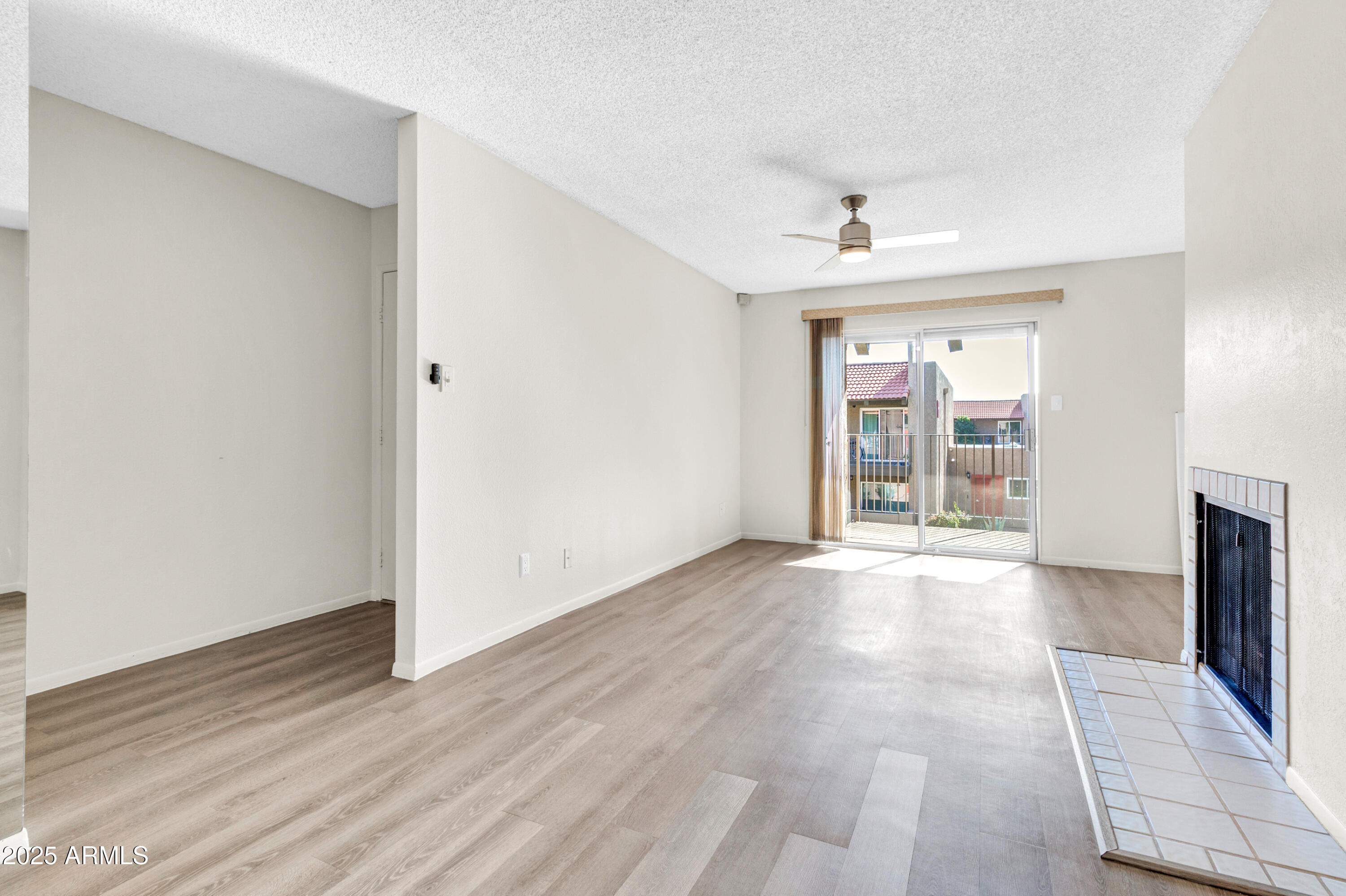 5525 East Thomas Road, Unit F9 Phoenix, AZ 85018 - Photo 12 of 48 a view of an empty room with a window and wooden floor