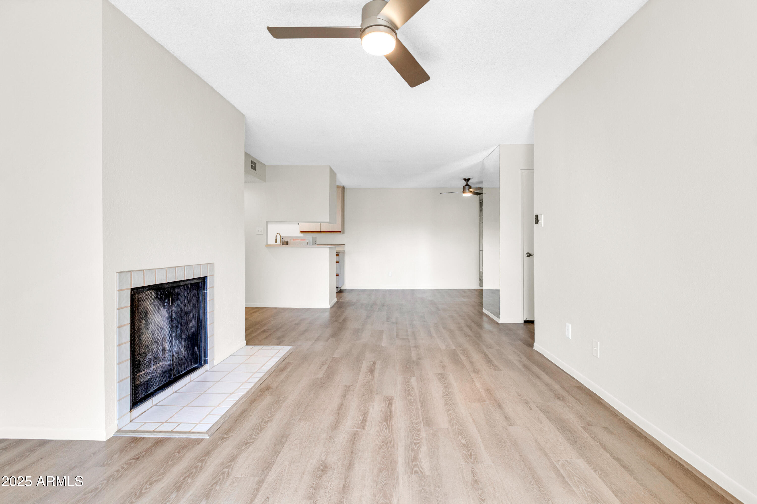 5525 East Thomas Road, Unit F9 Phoenix, AZ 85018 - Photo 19 of 48 a view of empty room with a fireplace and wooden floor