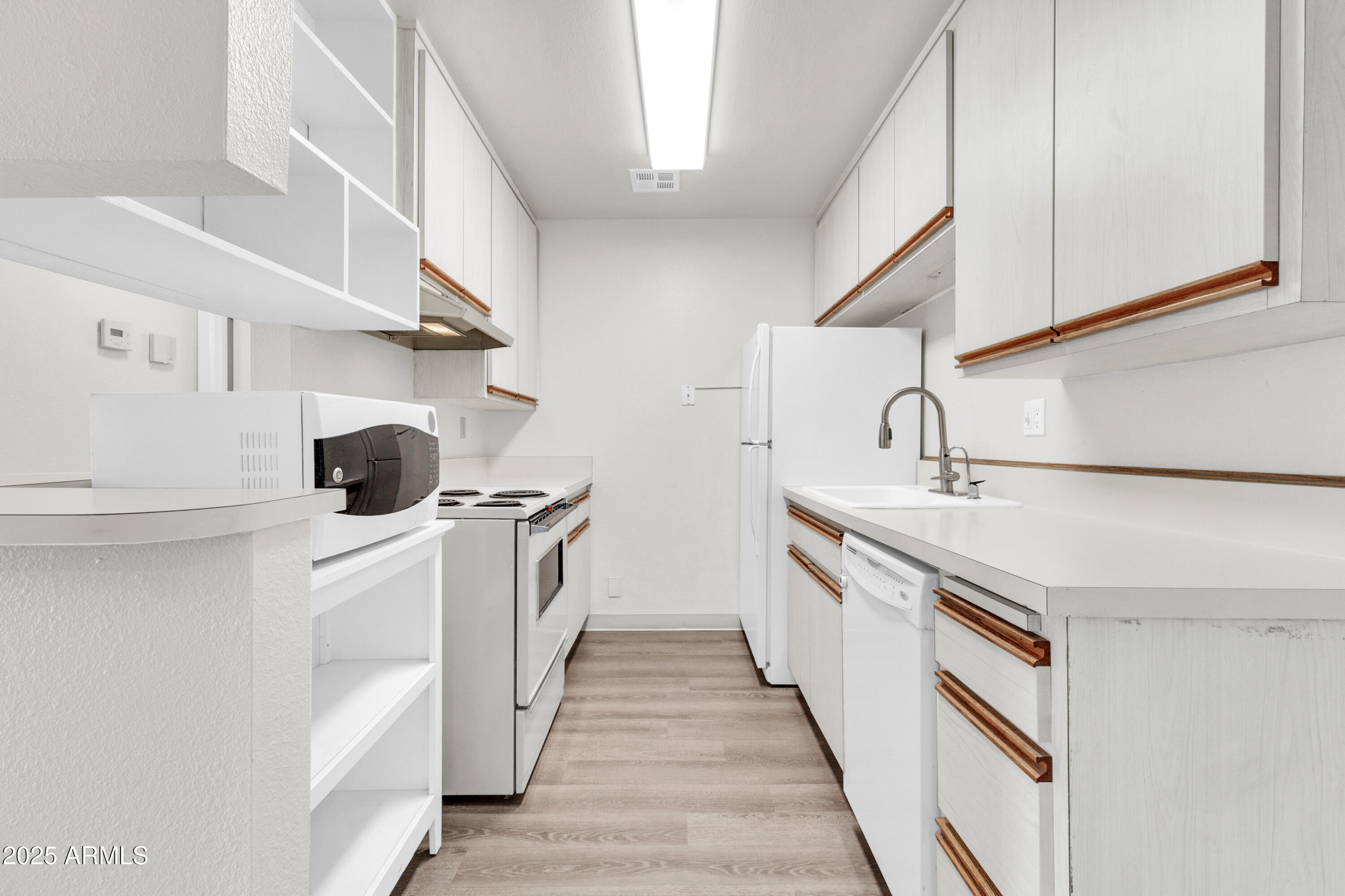 5525 East Thomas Road, Unit F9 Phoenix, AZ 85018 - Photo 24 of 48 a kitchen with white cabinets and white appliances
