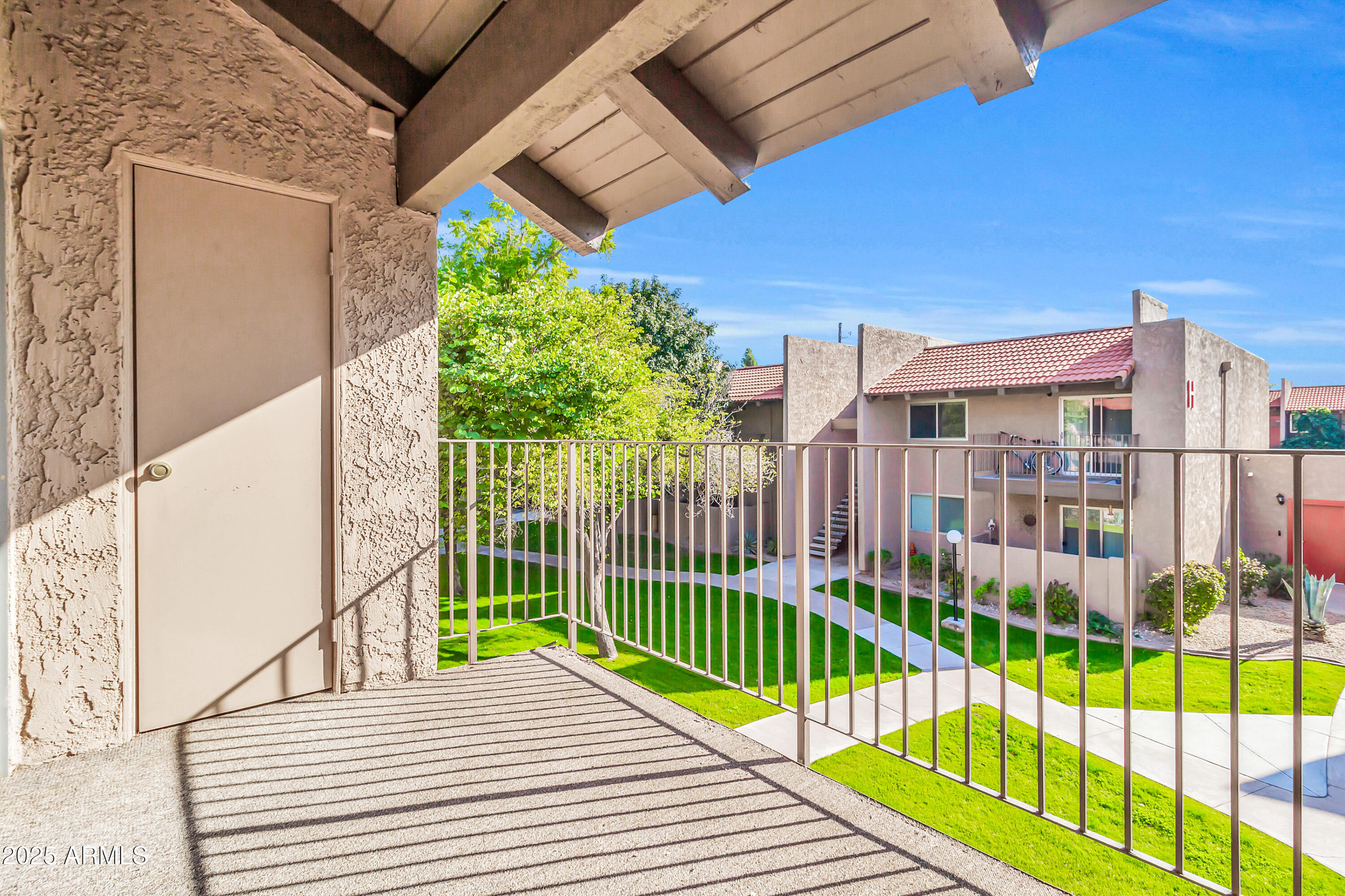 5525 East Thomas Road, Unit F9 Phoenix, AZ 85018 - Photo 46 of 48 a view of a balcony with a floor to ceiling window and wooden fence