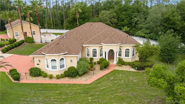 a aerial view of a house with yard and green space